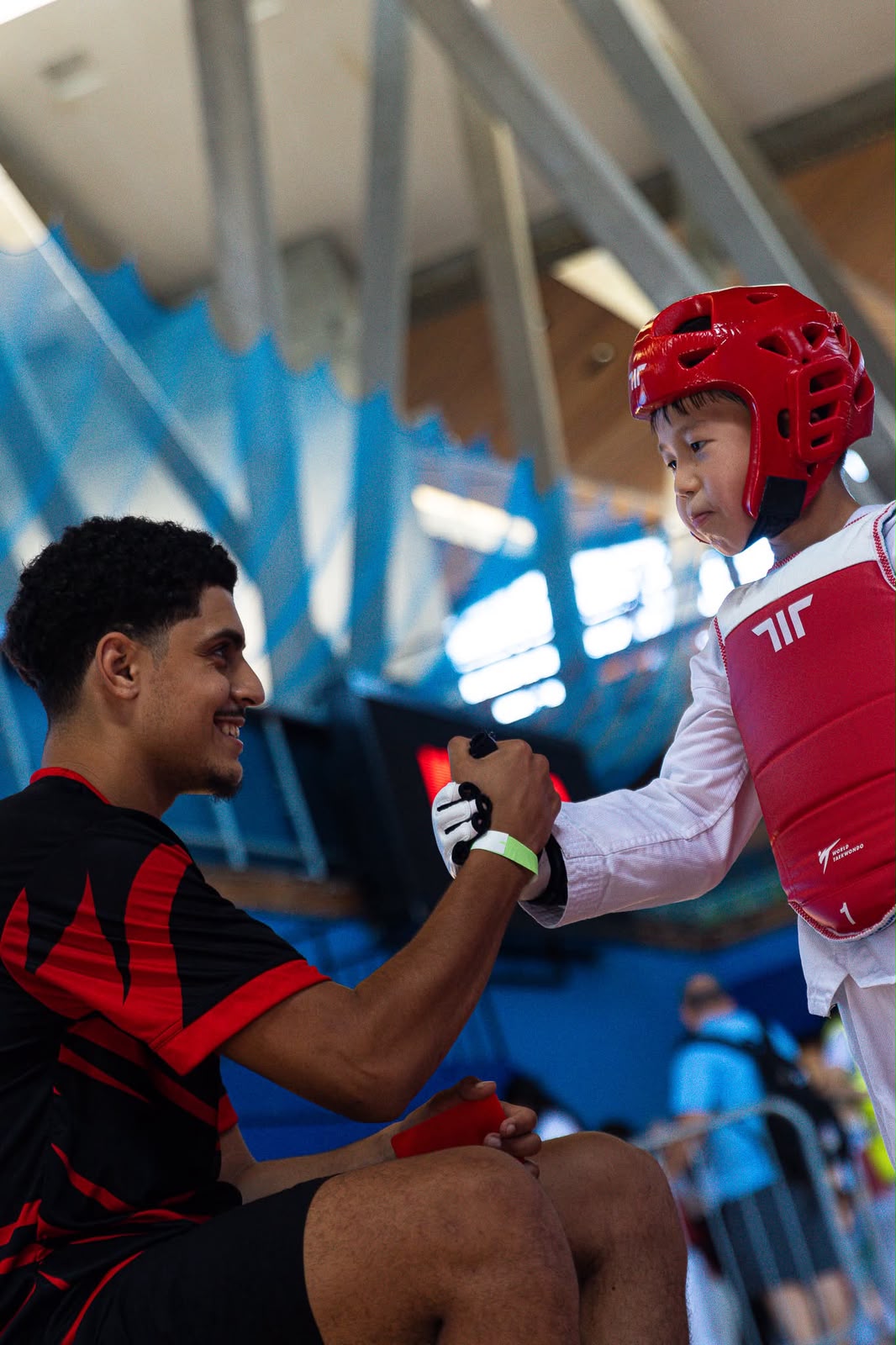 New Generation Taekwondo coach shaking hands with a young athlete at a competition